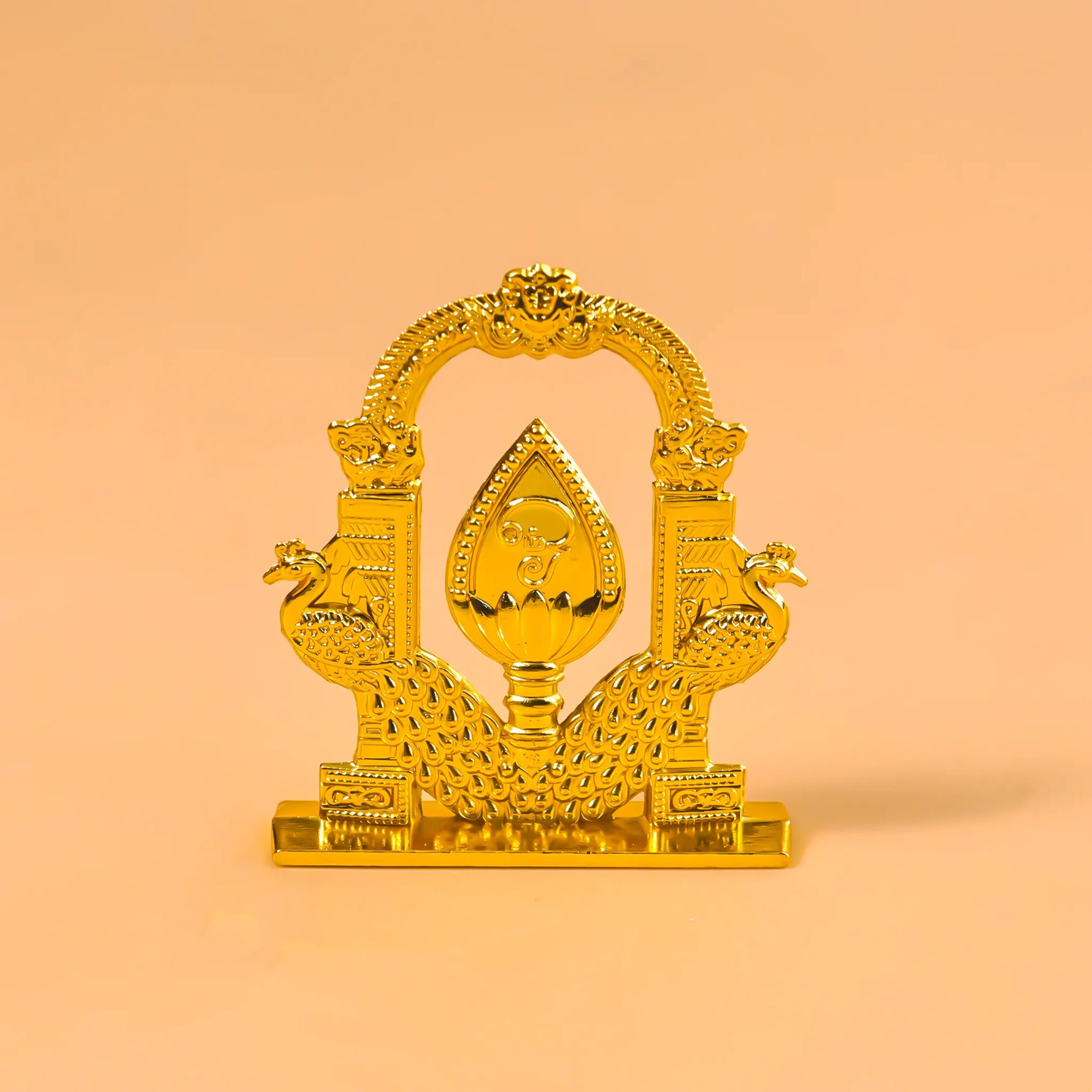 Decorative gold item with intricate designs on a peach backgroundMurugan 2 Peacock Vel – Divine Protection & Victory Symbol