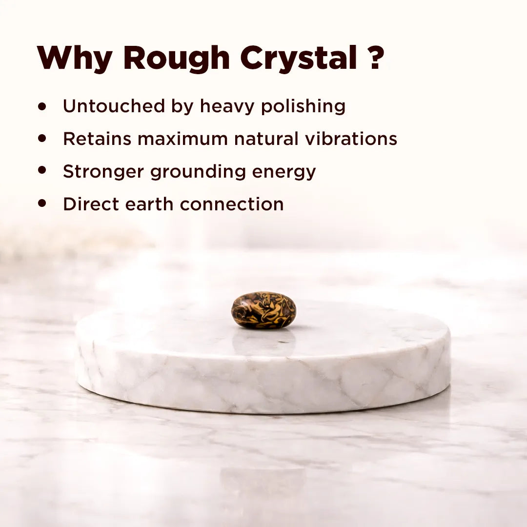 Rough crystal on a marble platform with text explaining benefits of using rough crystals.Mahe Mariyam Stone – Raw Protective Crystal for Energy Protection