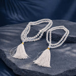 Crystal beaded necklace with tassels on a dark stone surface