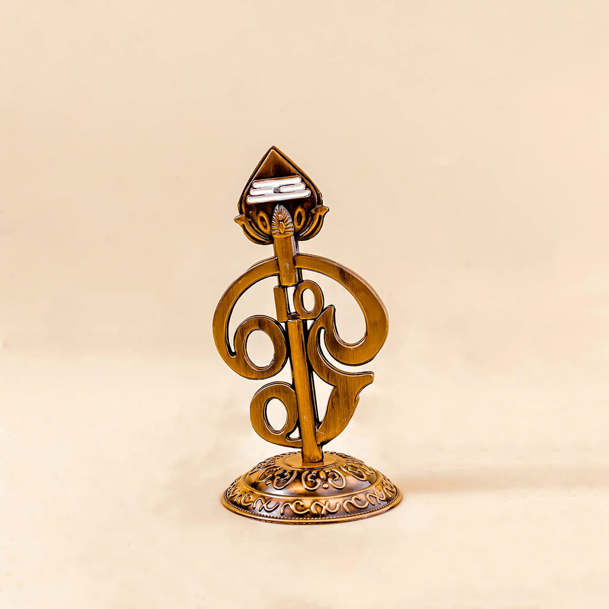 Decorative gold object with intricate design on a beige background