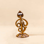 Decorative gold object with intricate design on a beige background