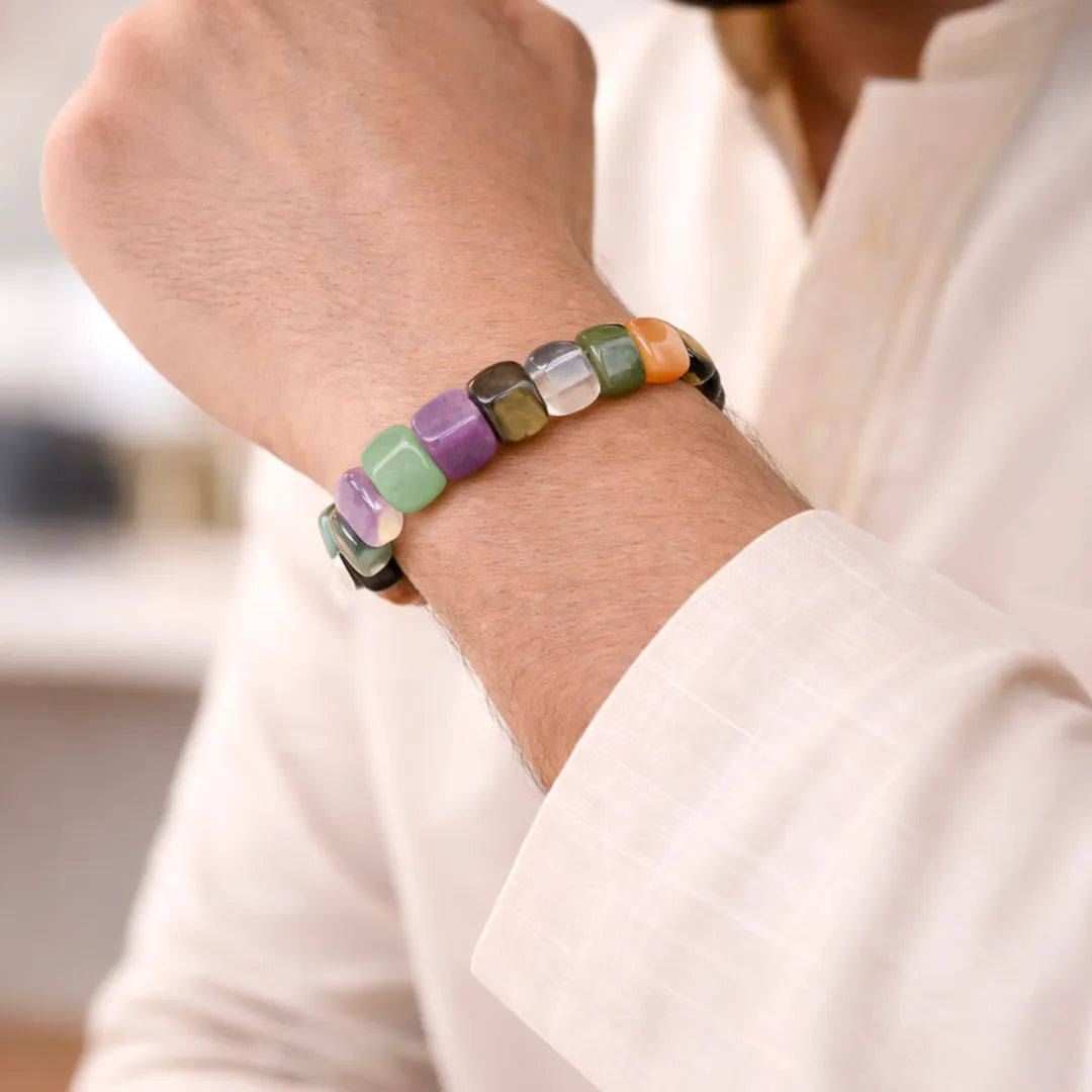 Multicolored beaded bracelet on a person's wrist with a blurred background