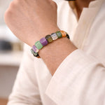 Multicolored beaded bracelet on a person's wrist with a blurred background