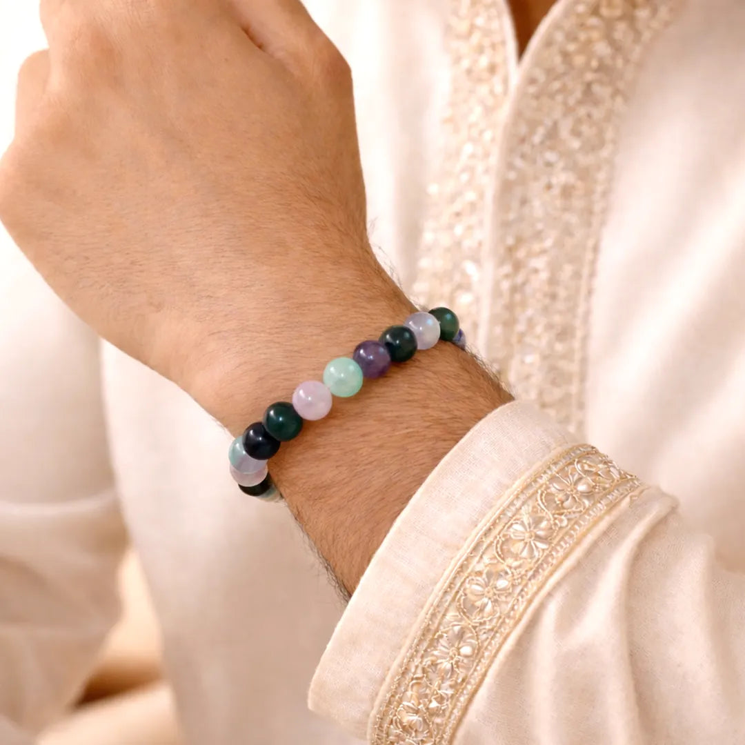 Close-up of a hand wearing a beaded bracelet on a light-colored garment.Pisces Zodiac Bracelet – Natural Multi Stone Bracelet for Intuition - Abhimantrit