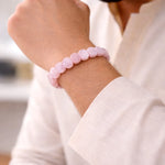 Pink beaded bracelet on a wrist with a blurred background