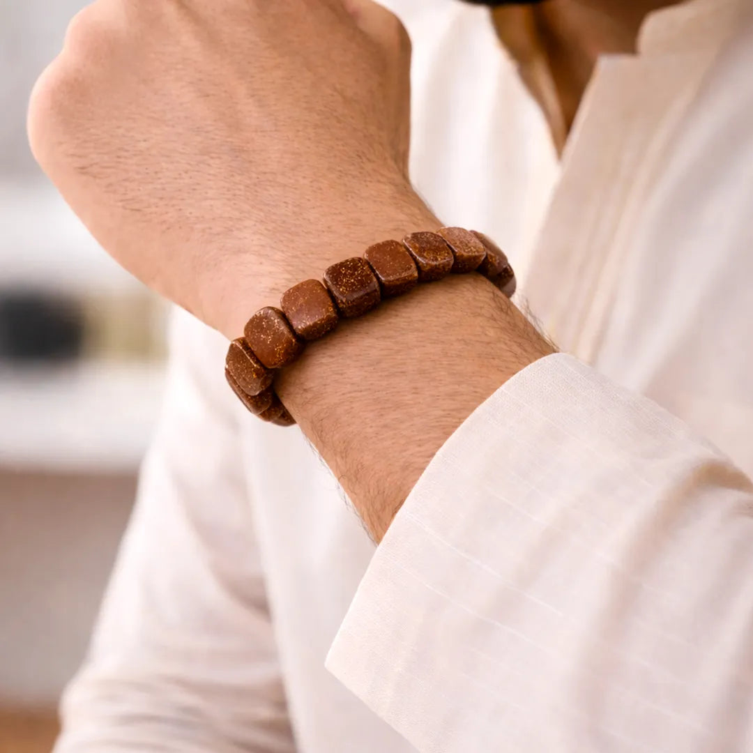 Brown beaded bracelet on a wrist with a blurred background