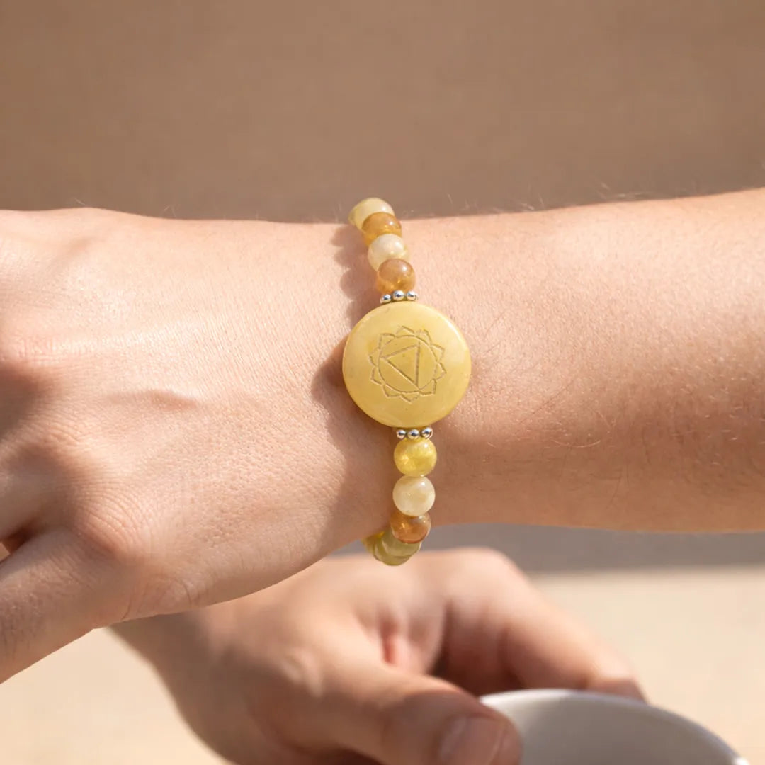 Close-up of a wrist wearing a beaded bracelet with a yellow disc charm against a neutral backgroundYellow Aventurine Solar Plexus Chakra Bracelet – Abhimantrit & Energized