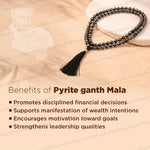 A dark metallic pyrite beaded necklace with a black tassel, styled on a beige textured background with text overlays detailing the benefits of a pyrite ganth mala.