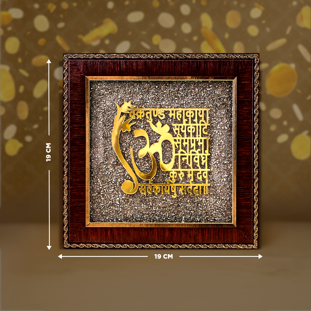 Decorative wall art with gold Om symbol and text in a wooden frame, on a brown background.Ganesh Mantra Raw Pyrite Frame - Success & Protection Frame