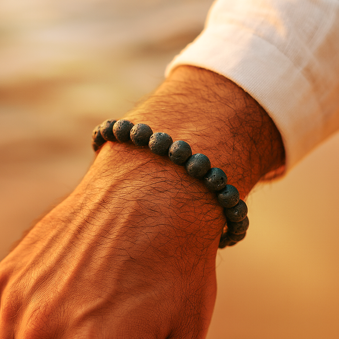 Close-up of a wrist wearing a dark beaded bracelet with a blurred natural backgroundLava Stone Bracelet - Grounding & Protection Energy Bracelet