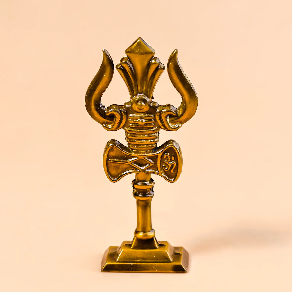 Decorative gold emblem with a central design on a beige background