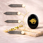 Black crystal with gold bull design on a beige surface, surrounded by decorative elements.