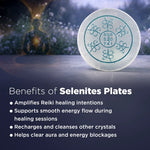 Selenite plate with energy symbols on a blurred background of a person in meditation.