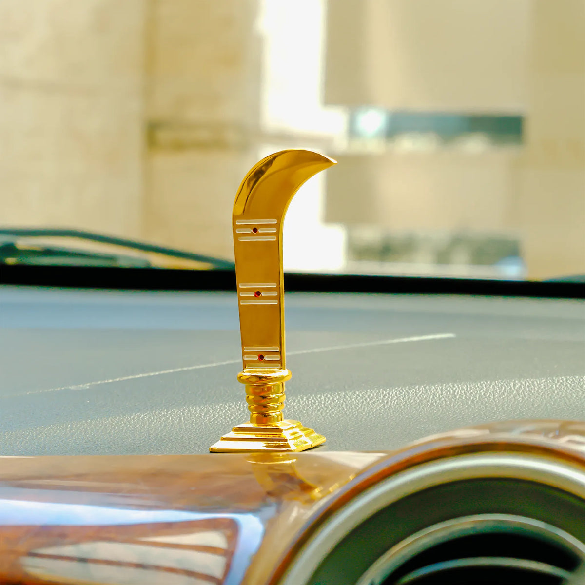 Gold car emblem on a car hood with a blurred background