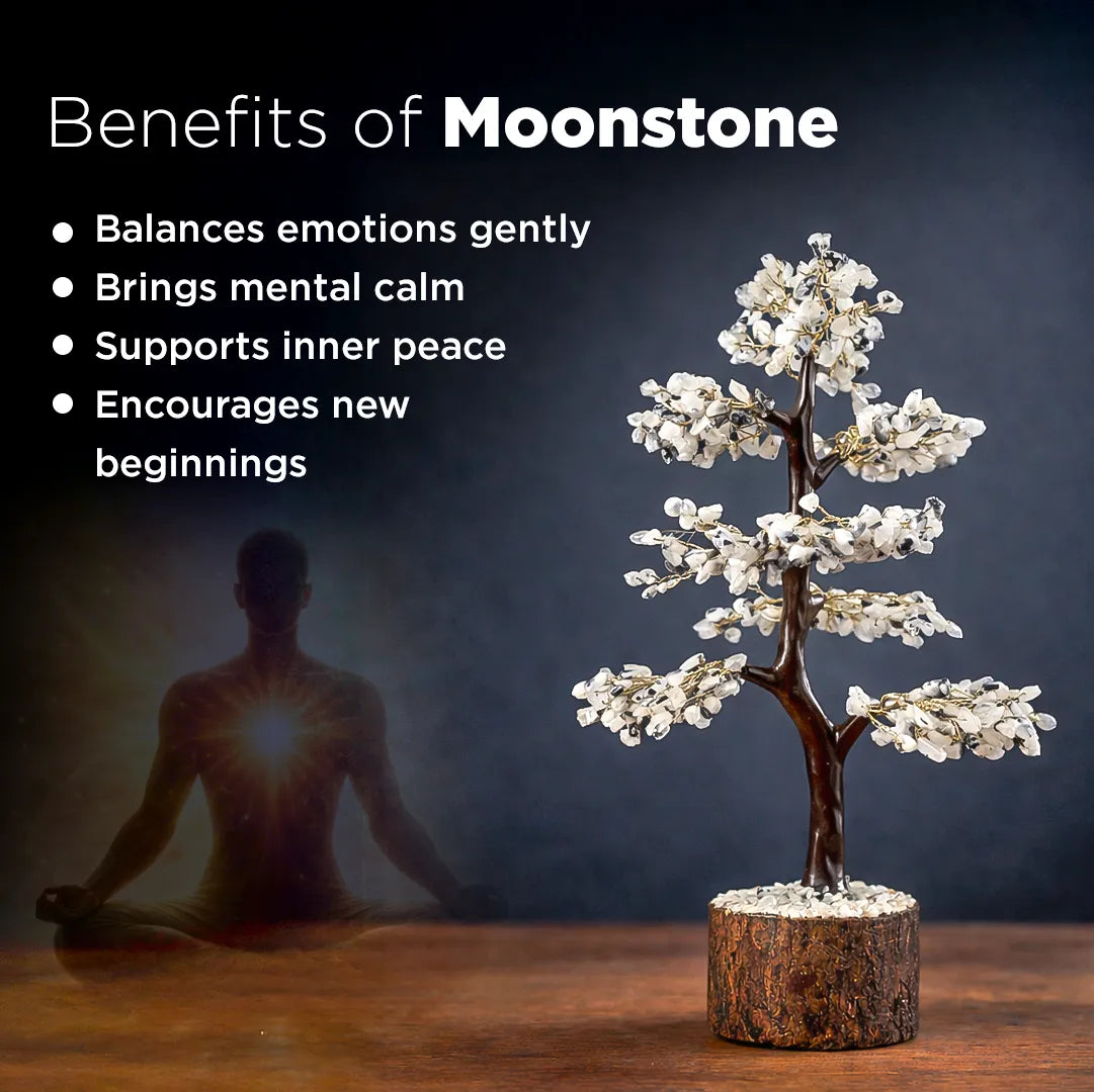 Tree-shaped moonstone sculpture with a person meditating, set against a dark background.