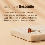 Hessonite ring on a marble surface with text about its benefits.