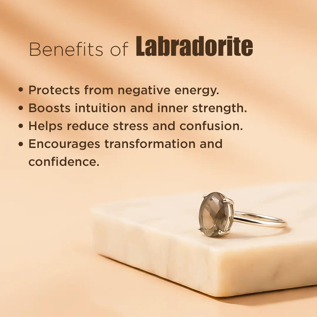 Silver ring with a Labradorite stone on a beige surface, with text about Labradorite benefits.