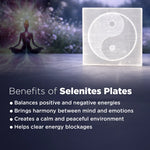 Selenite plate with yin yang symbol and meditation silhouette on a dark background