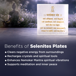 Selenite plate with Namokar Mantra text on a blurred background of a person meditating.