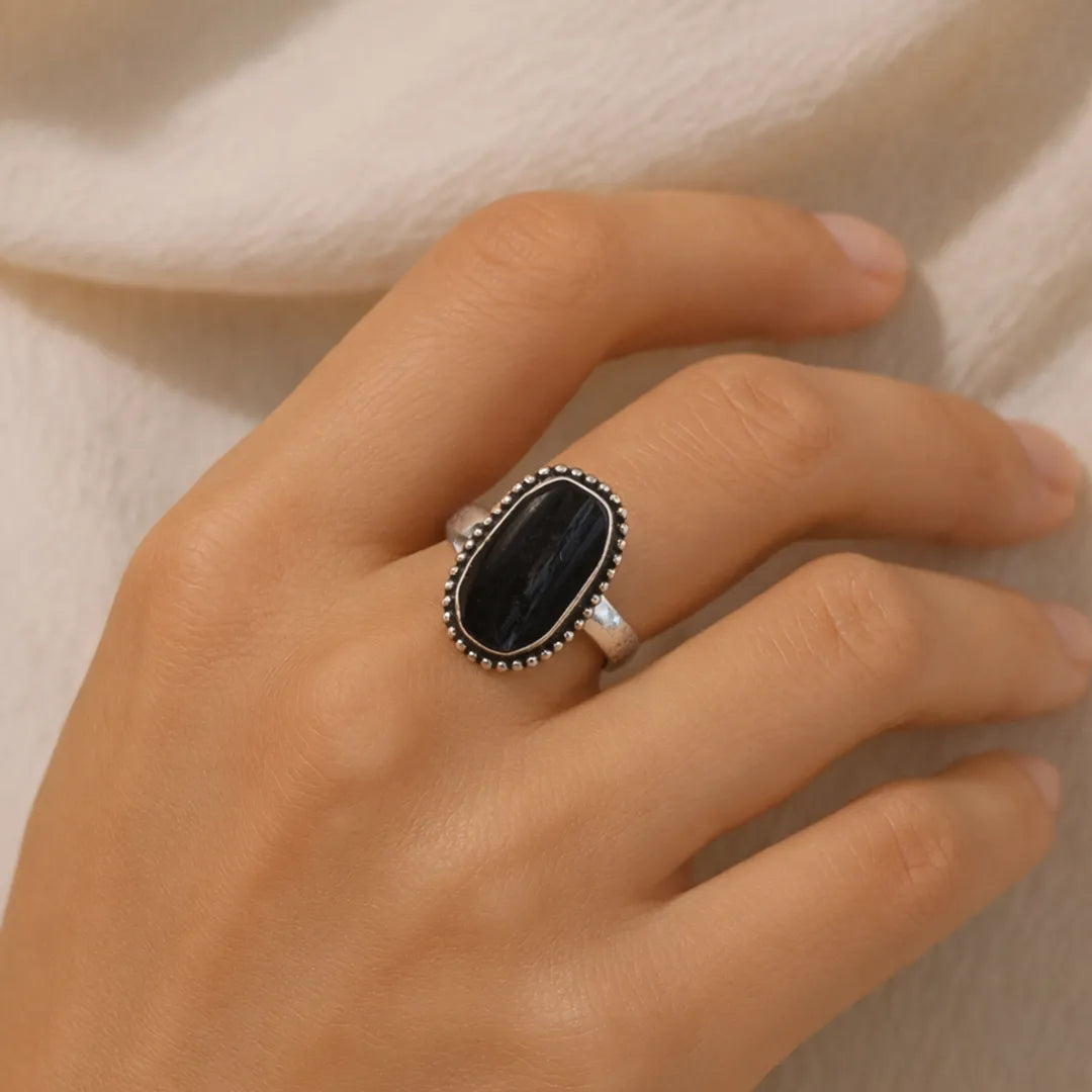 Hand wearing a silver ring with a black stone on a neutral backgroundBlack Tourmaline Ring: Protect from Psyhic attacks & Negative Engery