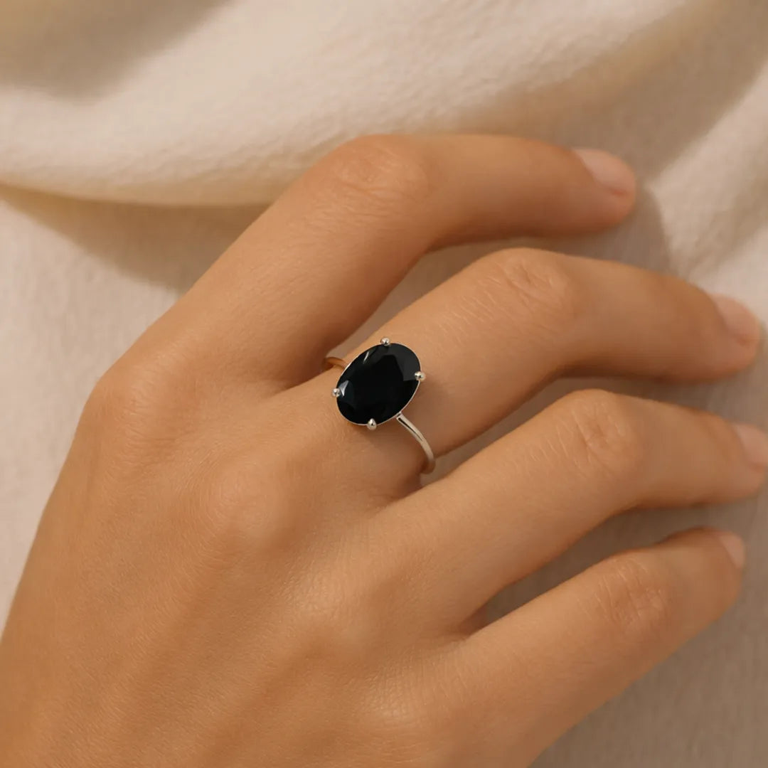Hand wearing a ring with a dark gemstone on a neutral backgroundBlack Tourmaline Ring – Ultimate Protection & Energy Shield