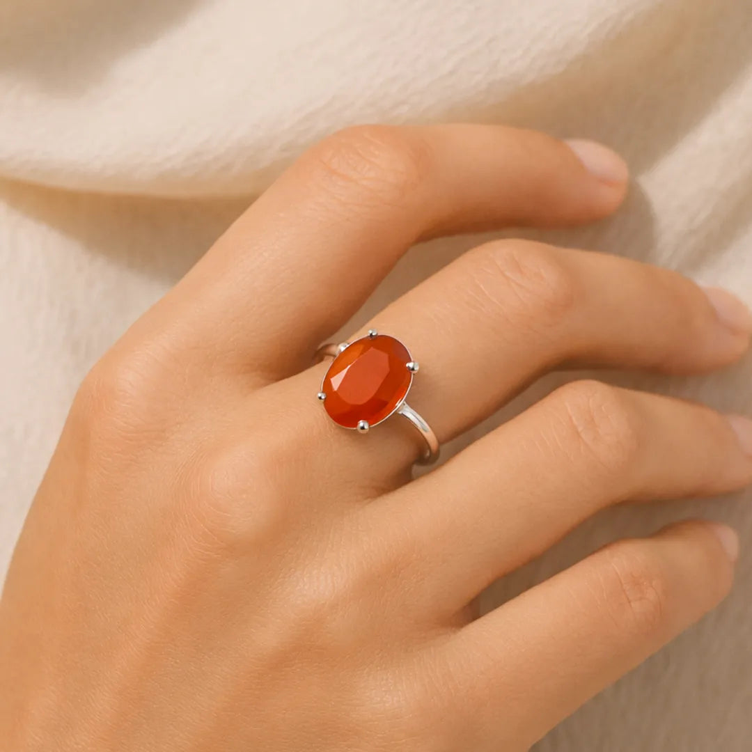 Hand wearing a silver ring with a red stone on a neutral backgroundElegant Carnelian Ring – Certified Stone for Vitality, Confidence & Wellness
