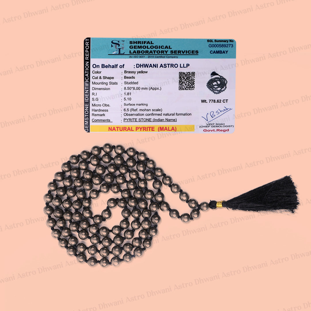 A beaded necklace of dark metallic beads with a black tassel, displayed below its official product label card on a solid peach background.एमिथेस्ट जाप माला- अभिमंत्रित और प्रमाणित