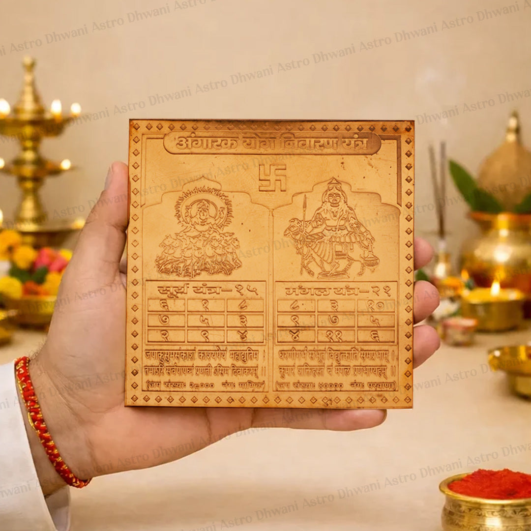 A hand holds a square wooden Hindu calendar plaque featuring Lord Shiva and Goddess Lakshmi, with Devanagari text and a swastika symbol at the top, set against a warm, decorated background with brass lamps and red powder.