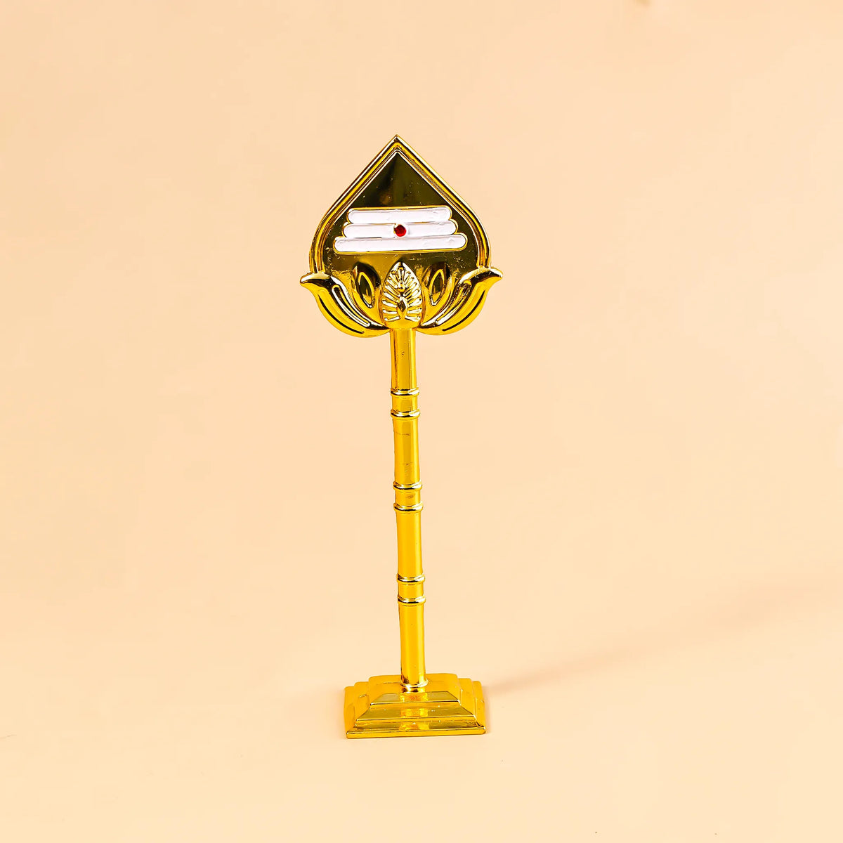 Decorative item with a gold base and a triangular top on a beige background