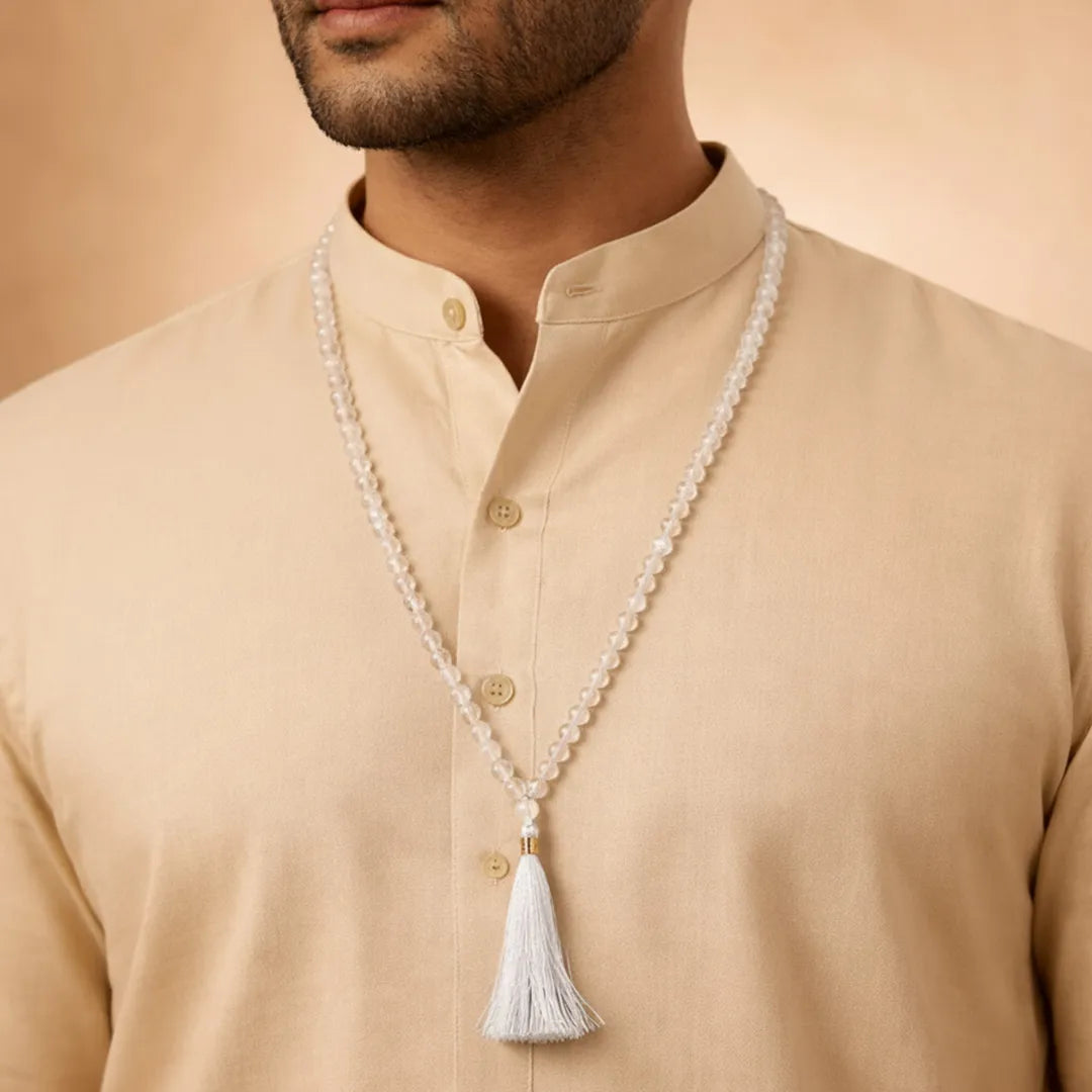 Man wearing a beige kurta with a long pearl necklace and tassel against a beige backgroundAura Quartz Crystal Mala – Positive Energy & Emotional Healing