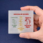 Hand holding a card with 'Hon Sha Ze Shonen' principles on a blue background
