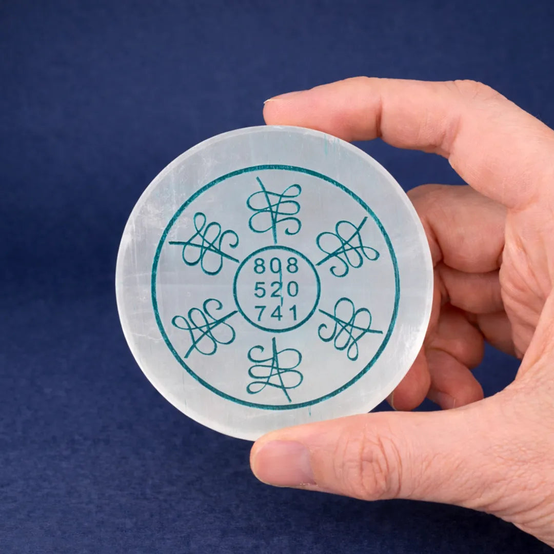 Hand holding a round white object with blue text against a dark blue background