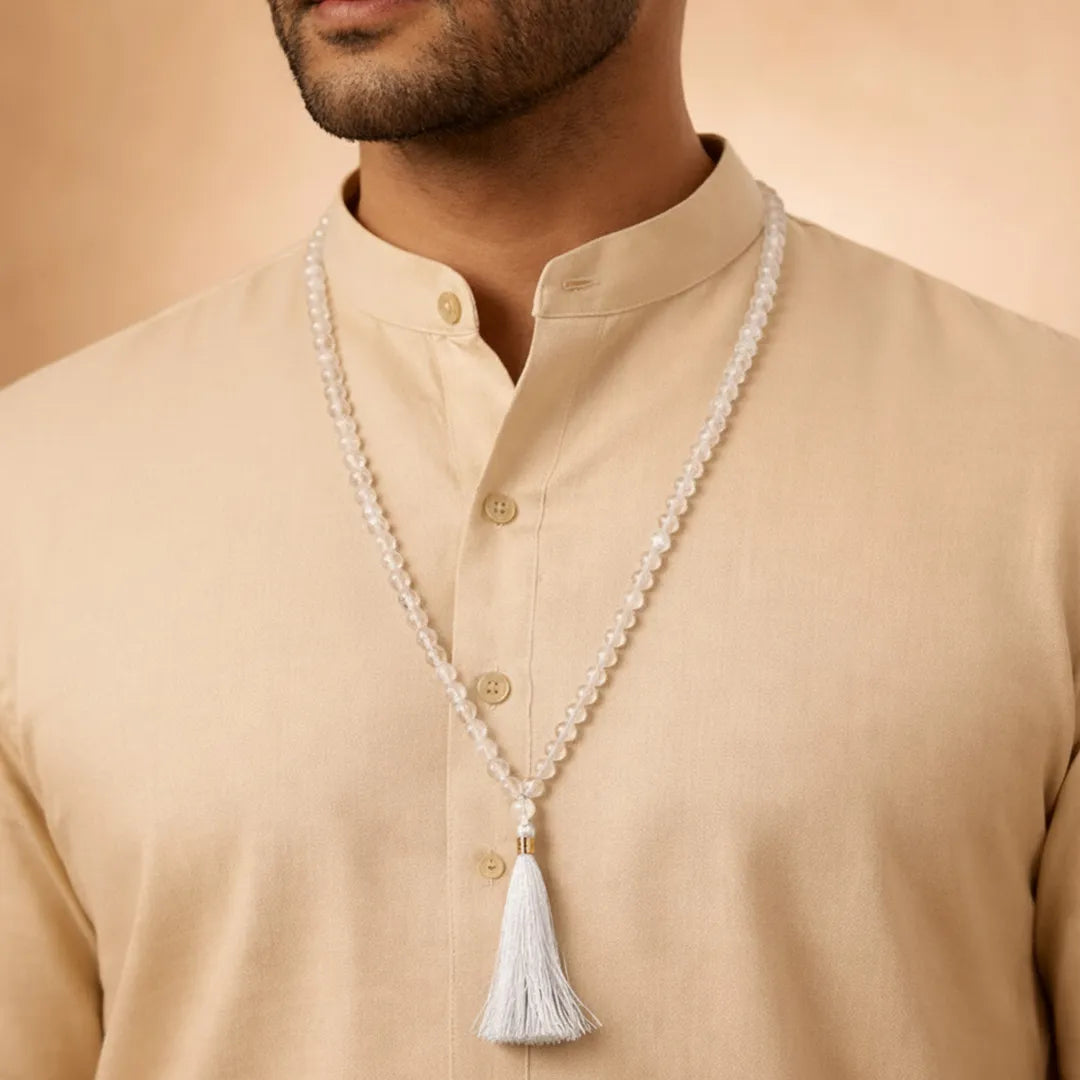 Man wearing a beige shirt with a long pearl necklace featuring a tassel.Clear Quartz Crystal Mala – Master Healer Meditation