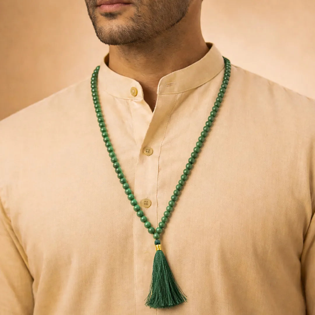 Man wearing a beige shirt with a green beaded necklace and tassel.Green Aventurine Crystal Mala – Luck, Opportunity & Financial Growth