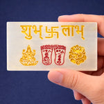 Hand holding a card with gold and red symbols and text against a blue background