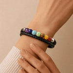 Bracelet with colorful beads on a wrist against a beige background