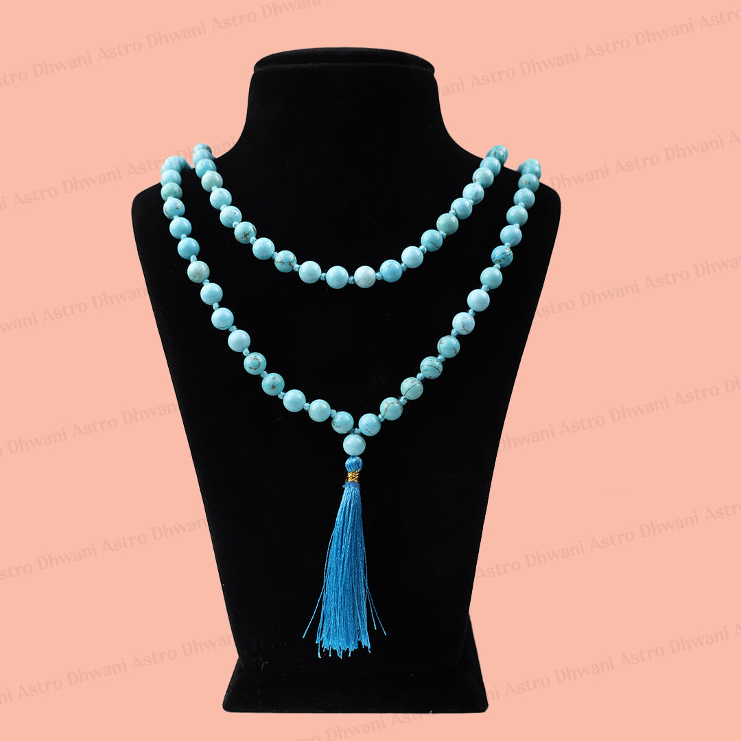 A double-strand light blue beaded necklace with a matching tassel, displayed on a black velvet jewelry bust