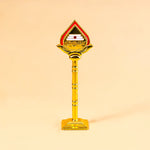 Decorative object with a red top and gold body on a beige background