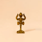 Gold decorative item with a unique design on a beige background