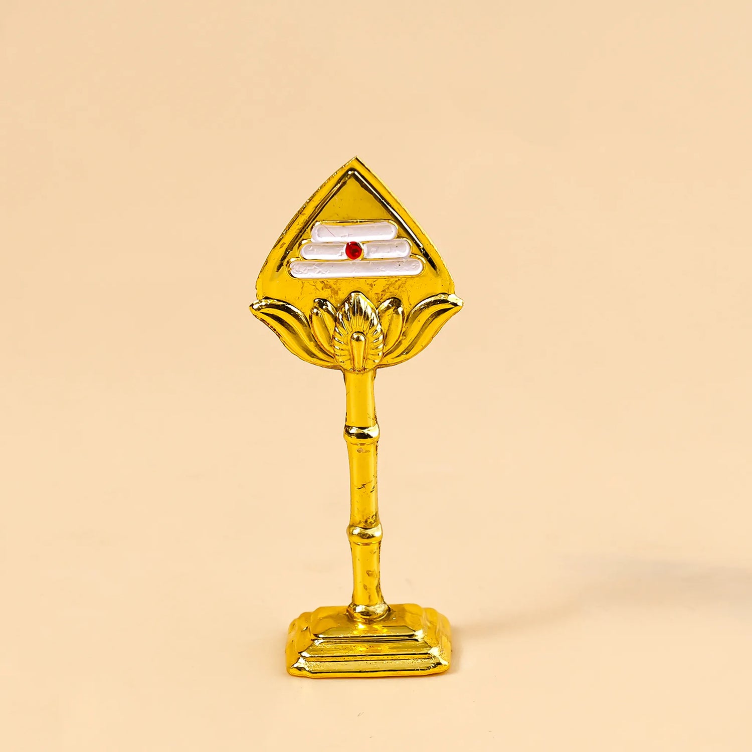 Gold-colored decorative item on a beige background