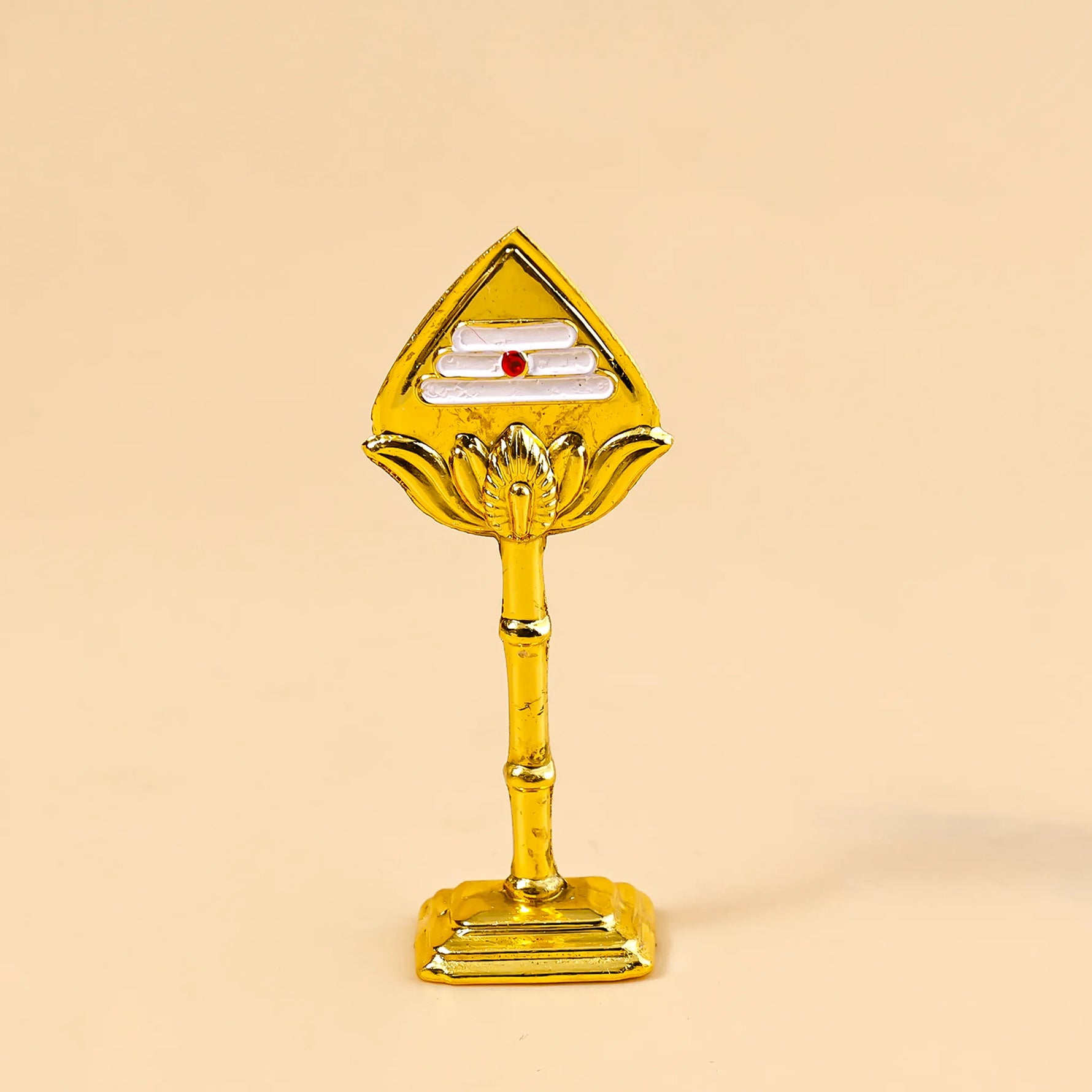 Gold-colored decorative item on a beige background