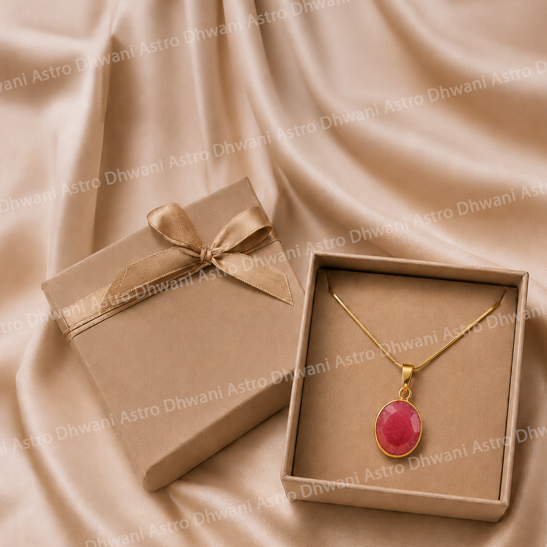 Gold necklace with a pink pendant in an open box on a beige fabric background