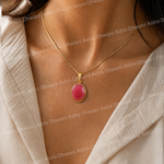 Necklace with a pink pendant worn by a person, with 'Astro Dhwani' branding in the background.