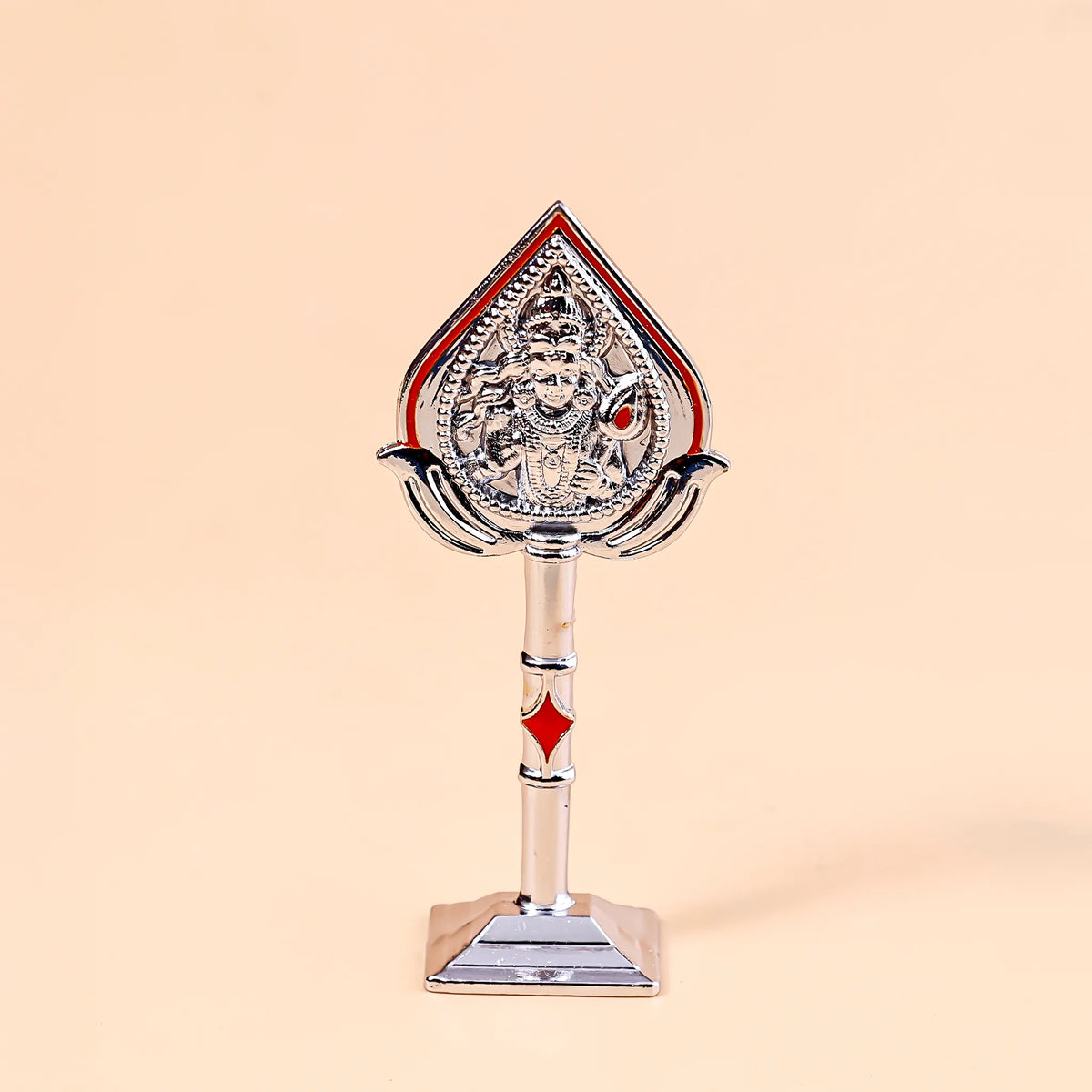 Decorative object with a figure on a stand against a beige background