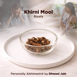 Glass bowl with dried roots on a white surface, with people in the background.