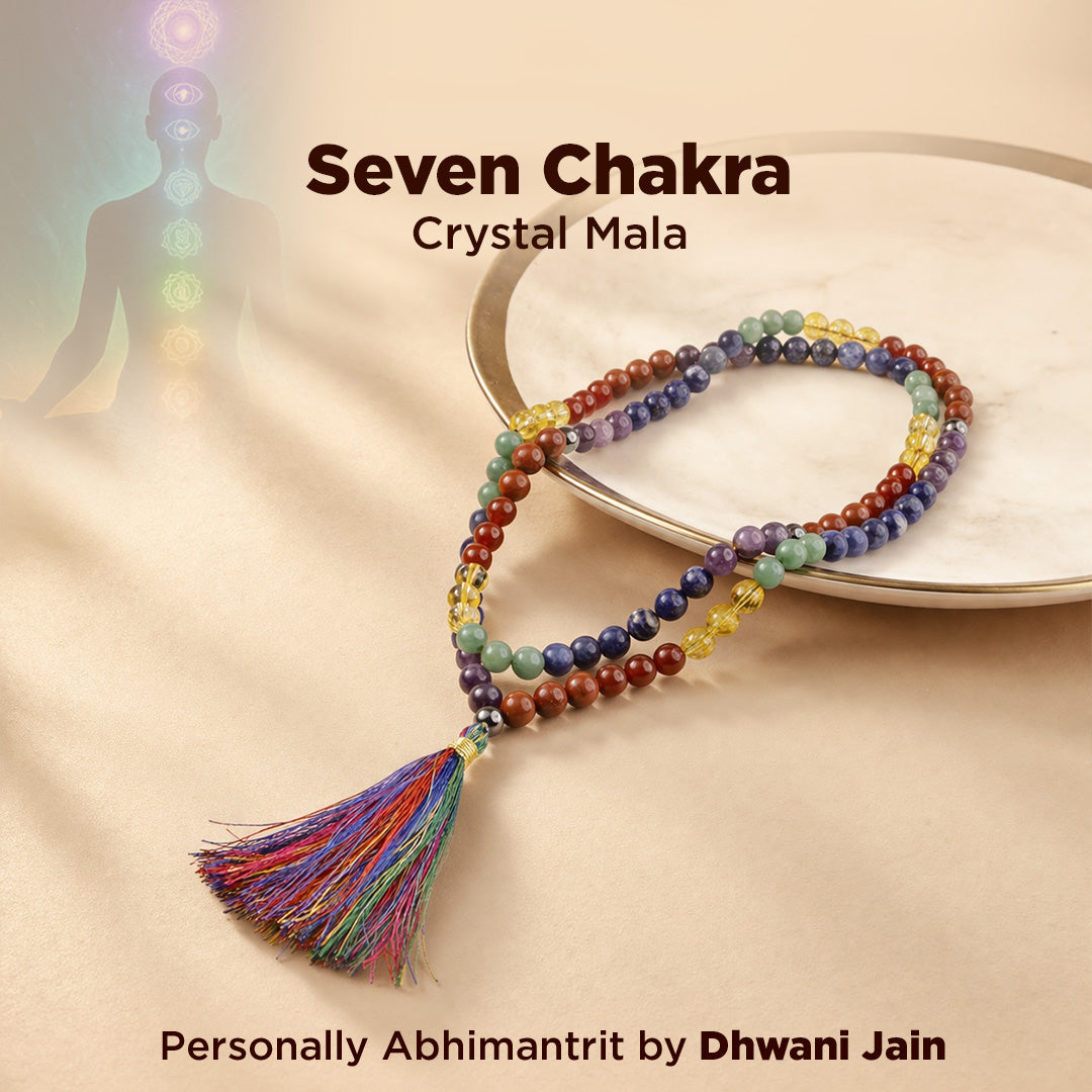 Seven Chakra Crystal Mala on a beige background with a silhouette of a person and colorful beads.