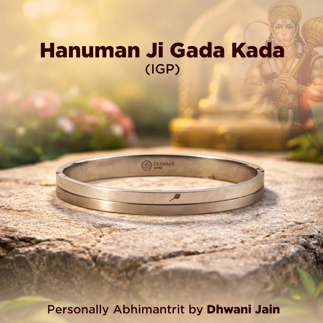 Silver bracelet on a stone surface with a blurred background of a statue and flowers.