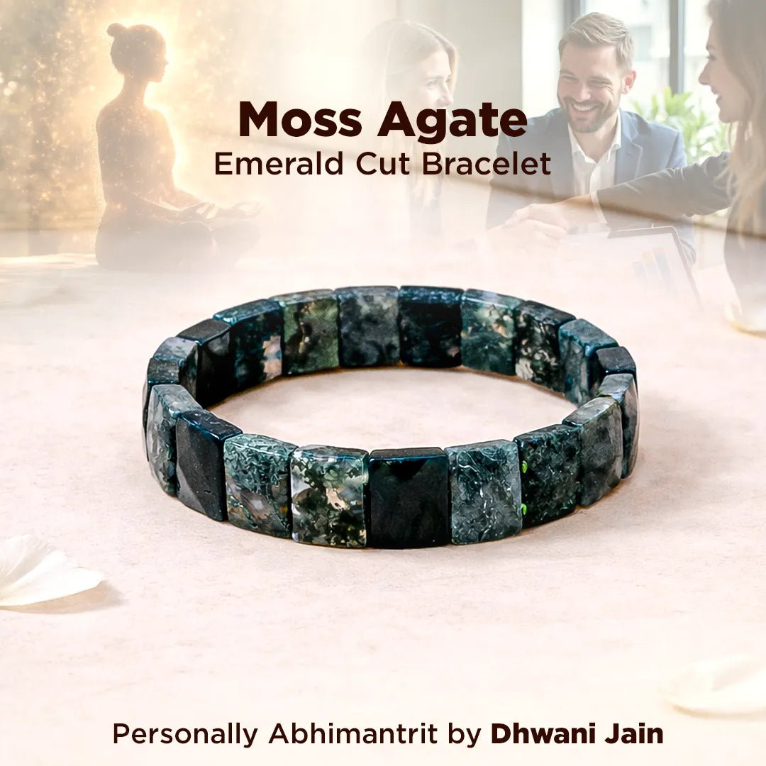 Moss Agate Emerald Cut Bracelet on a soft surface with a blurred background of people interacting.