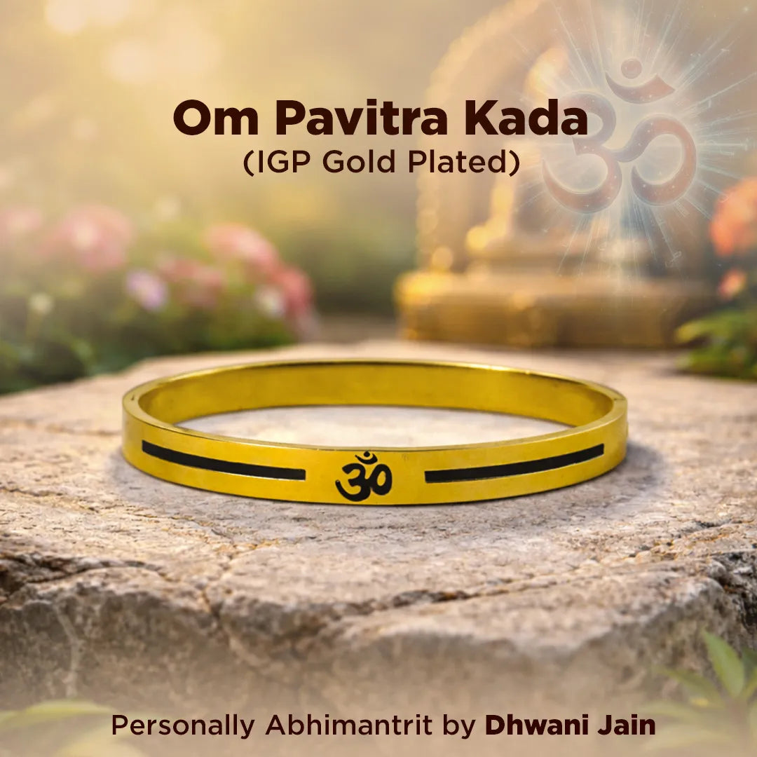 Gold bracelet with Om symbol on a stone surface with blurred background