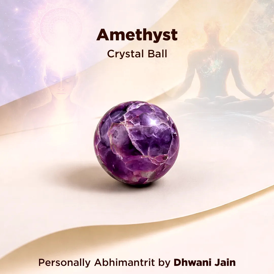 Amethyst crystal ball on a white surface with a blurred figure in the background